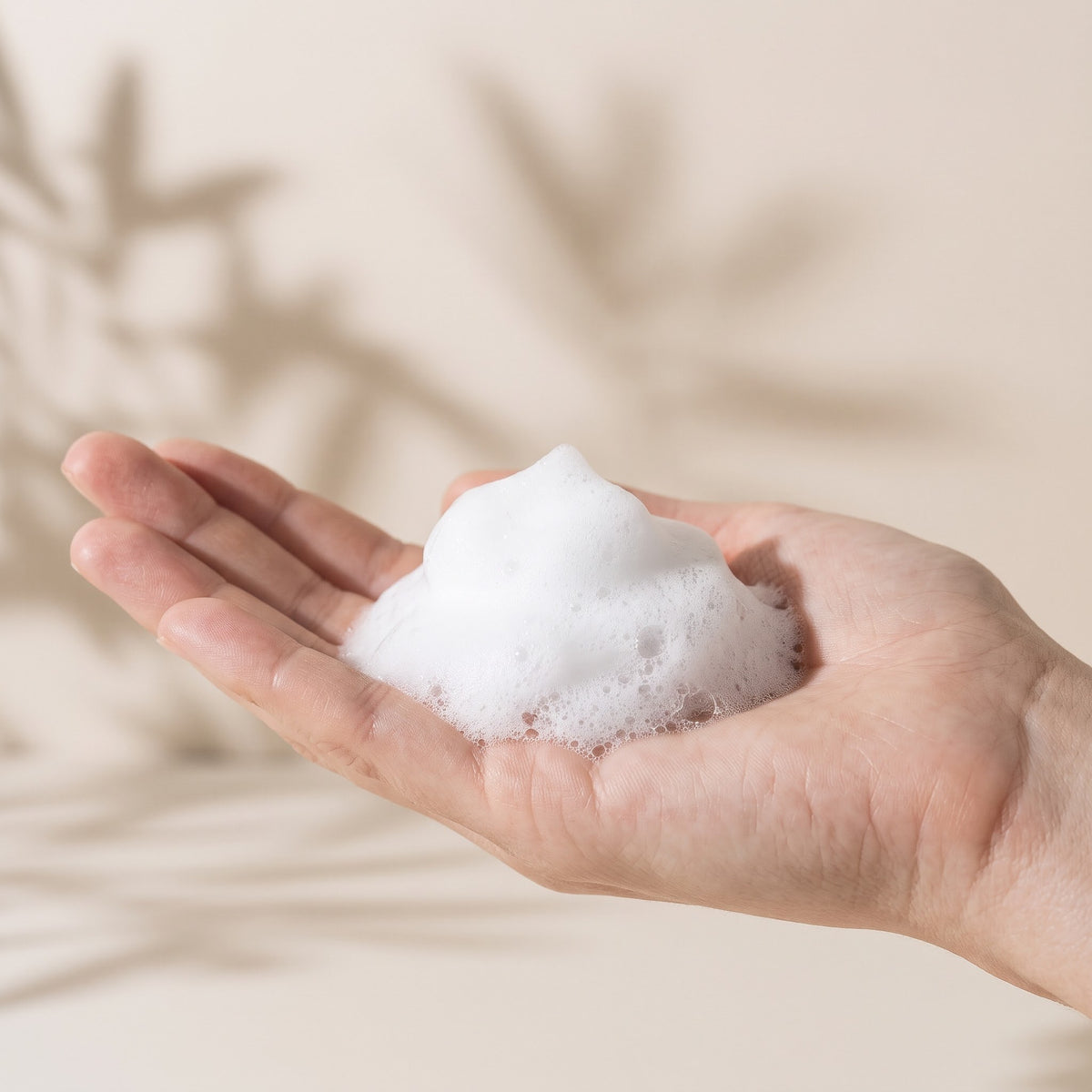 Schiuma della mousse detergente viso sul palmo della mano